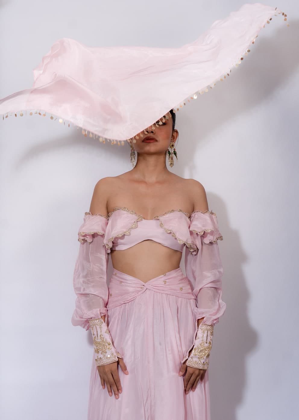 Jasmine set in blush pink, the scarf held overhead and caught in the light